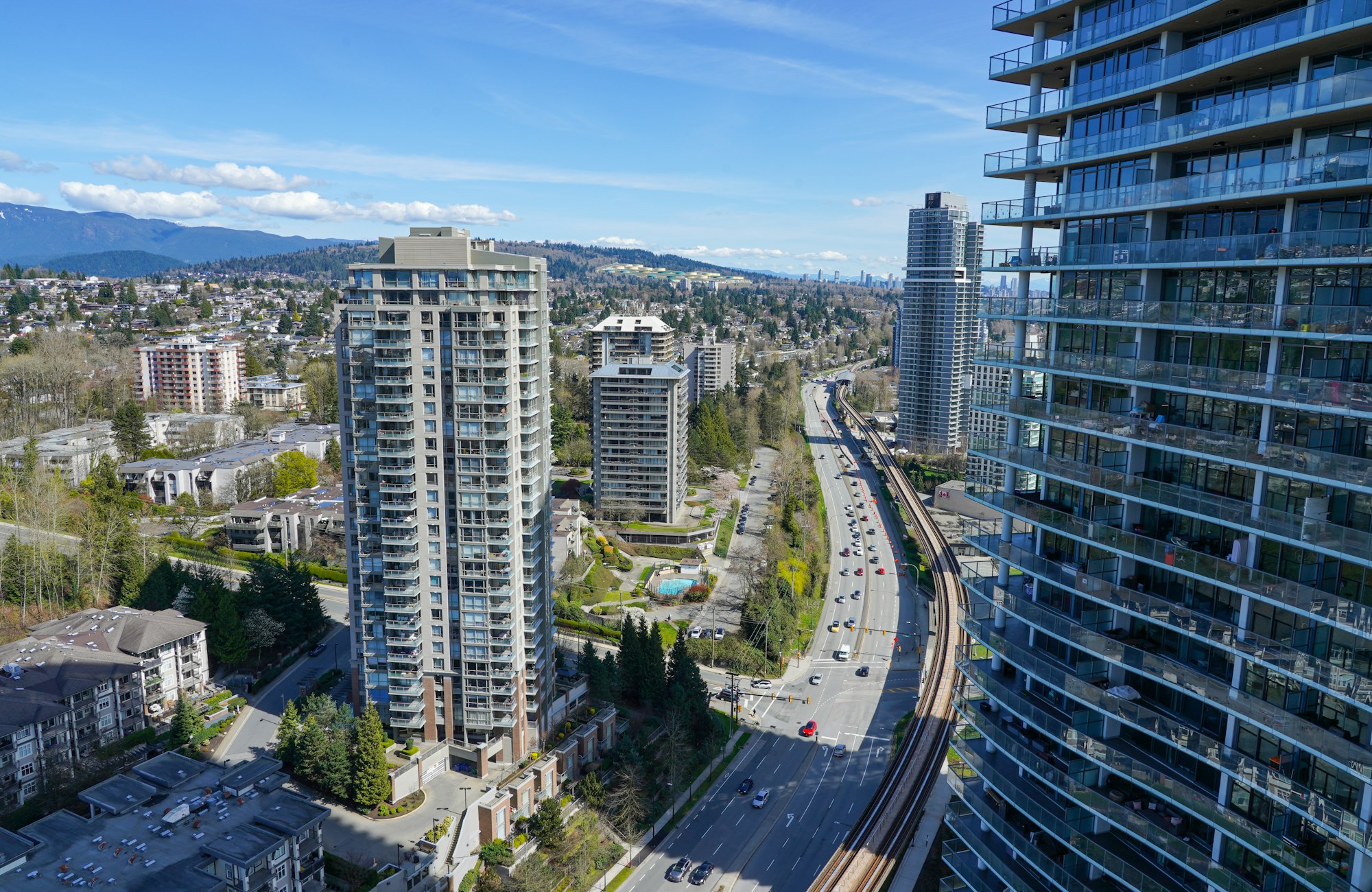 Burnaby towers with the SkyTrain, highway and North Shore mountains