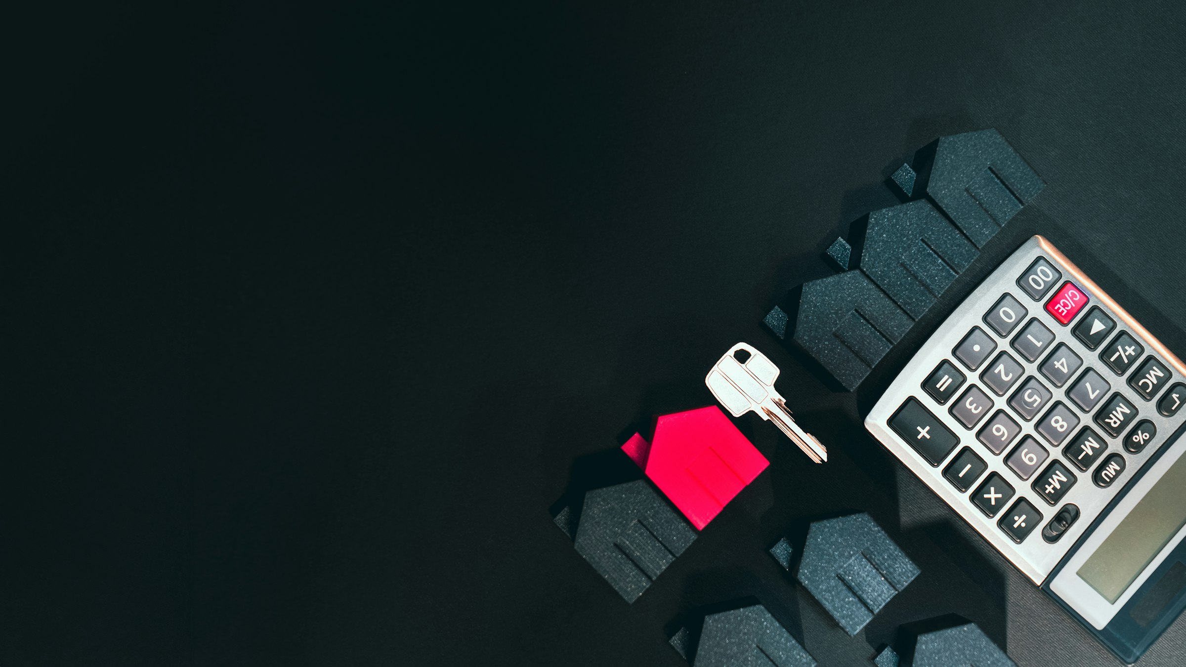 House key, a calculator and model houses for working out a mortgage