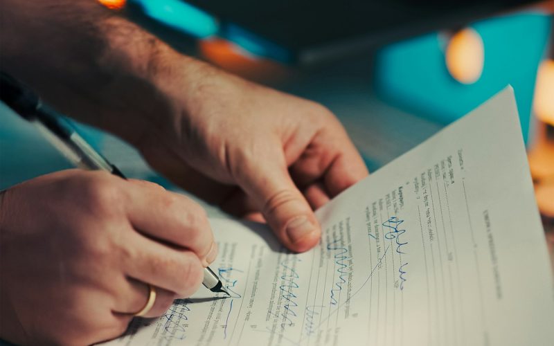 Buyer reading and signing a pre-sale purchase contract