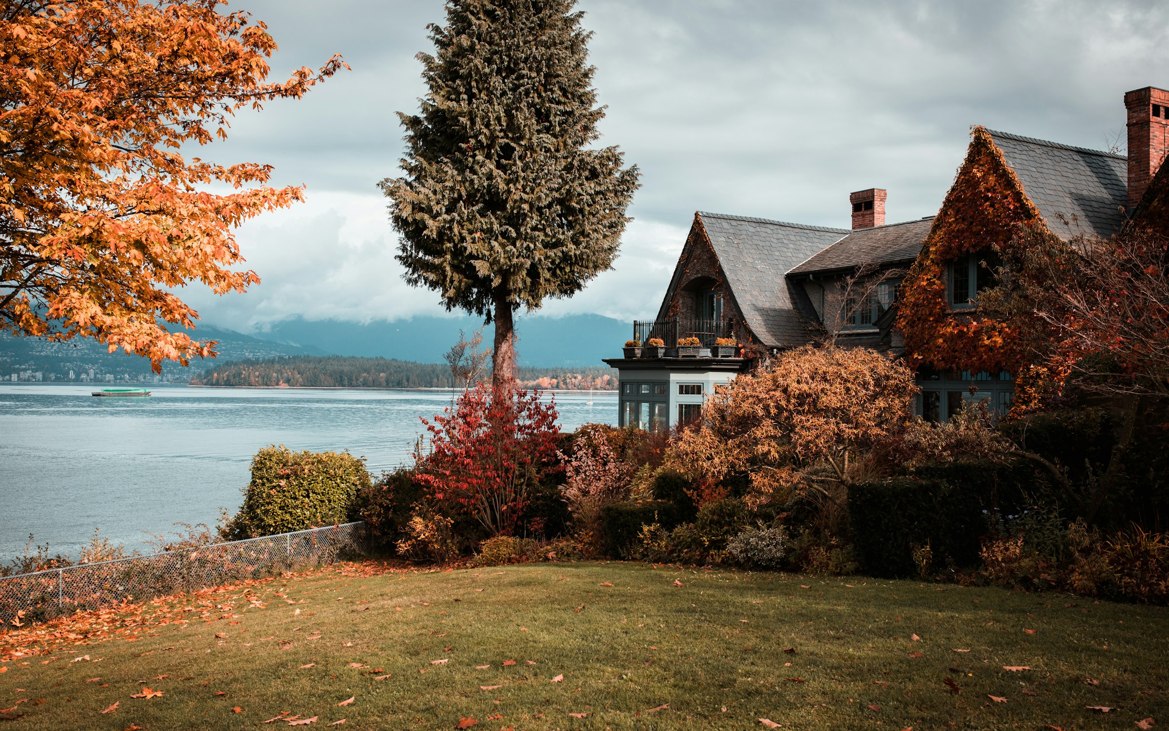 A home by the water with mountains behind it